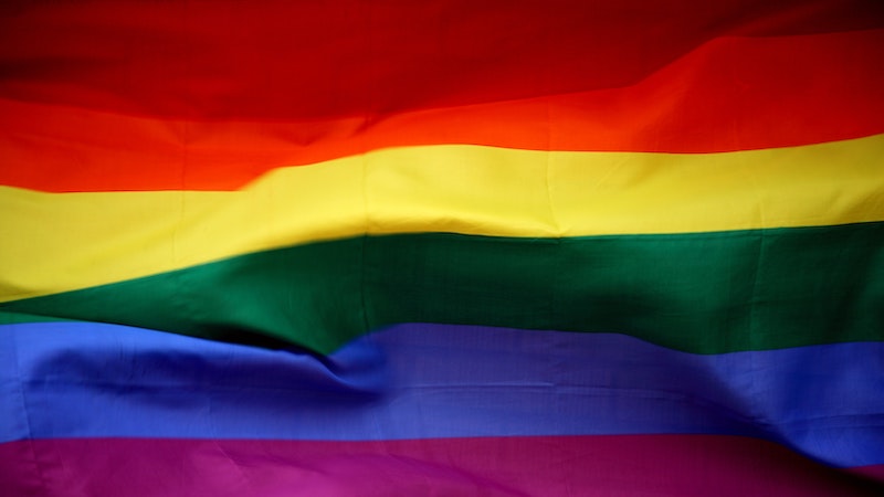 Slightly creased rainbow flag with red, orange, yellow, green, blue, violet